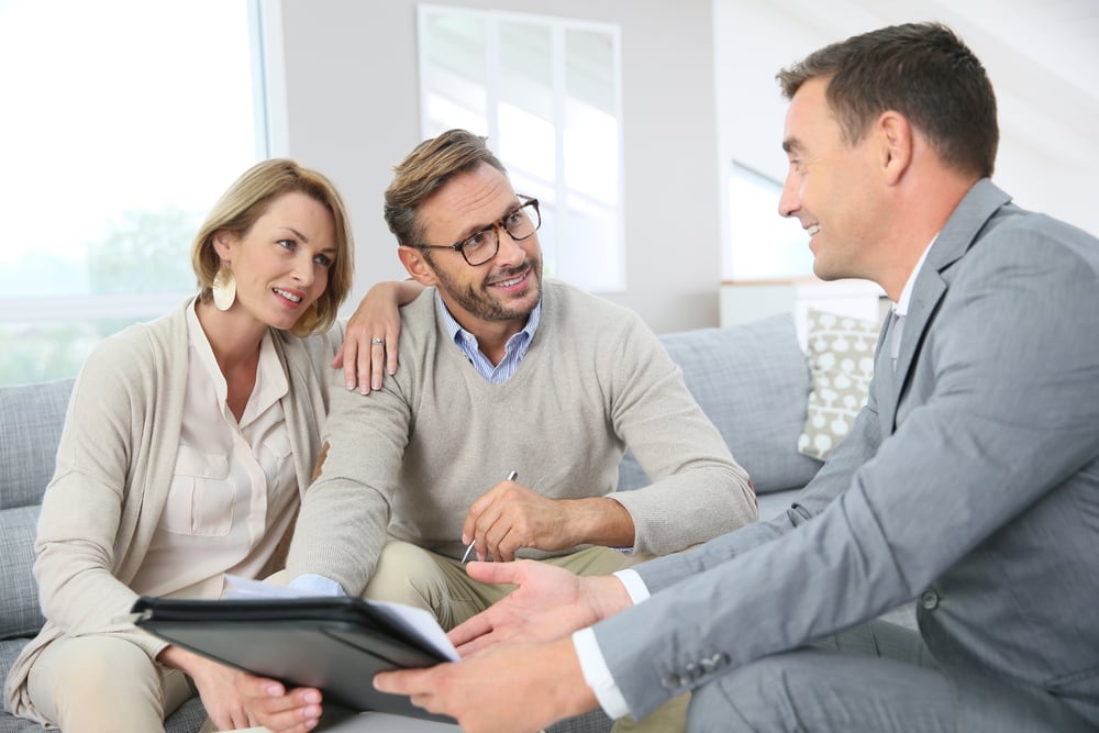 Couple with realtor signing mortgage contract