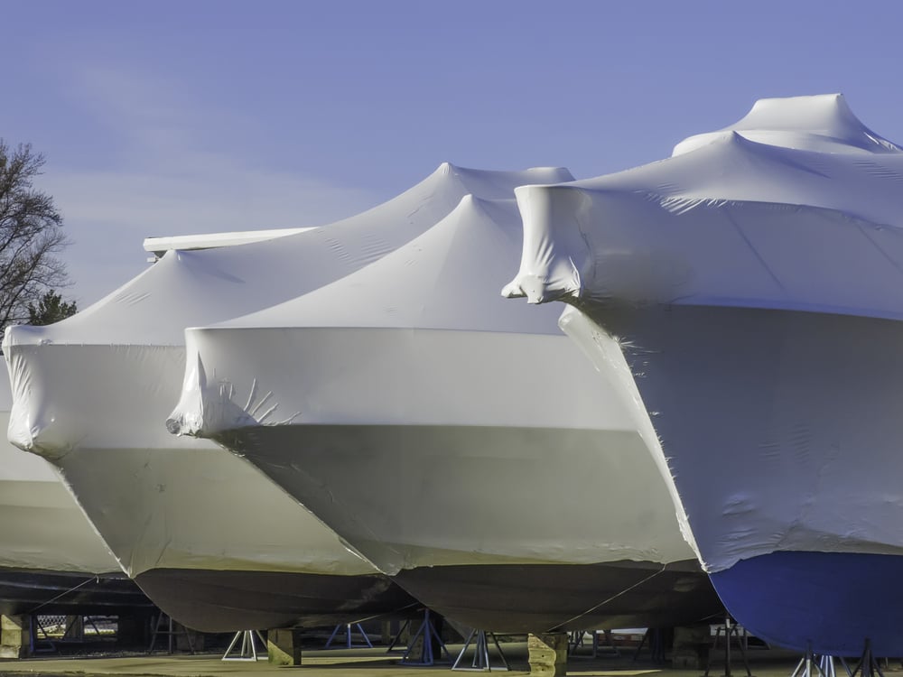 Waiting for nice weather is part of a lifestyle Bows of shrink-wrapped yachts in boatyard on a sunny morning, spring in southwestern Michigan Waiting for nice weather is part of a lifestyle Bows of shrink-wrapped yachts in boatyard on a sunny morning, spring in southwestern Michigan