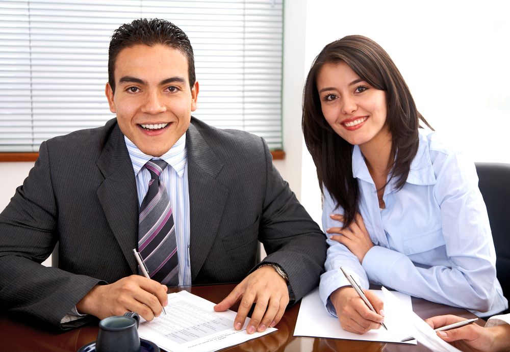 business woman with her partner in an office smiling